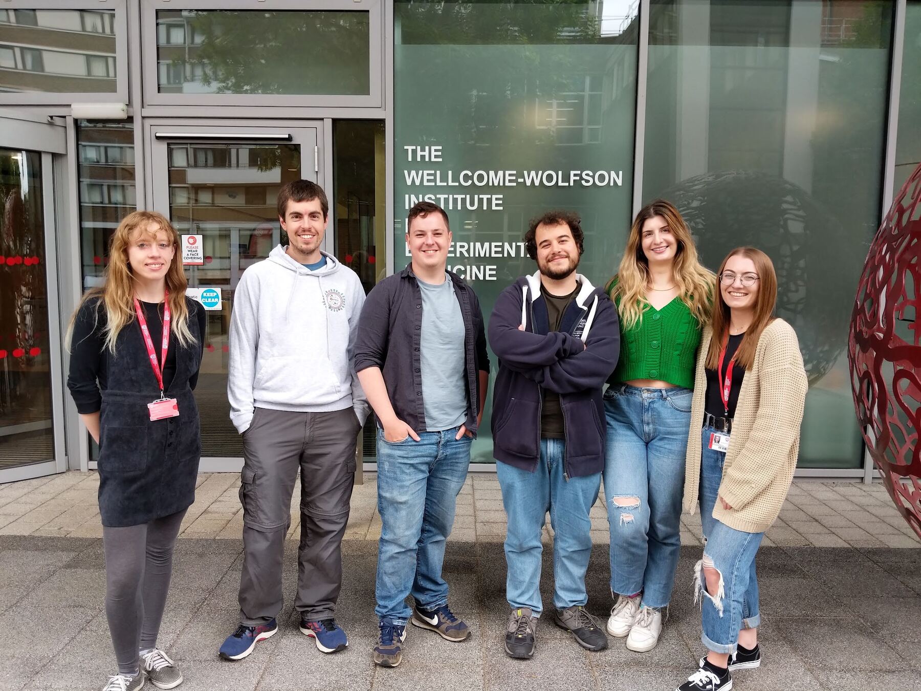 Members of The Courtney Group standing outside the Wellcome-Wolfson Institute for Experimental Medicine in Belfast